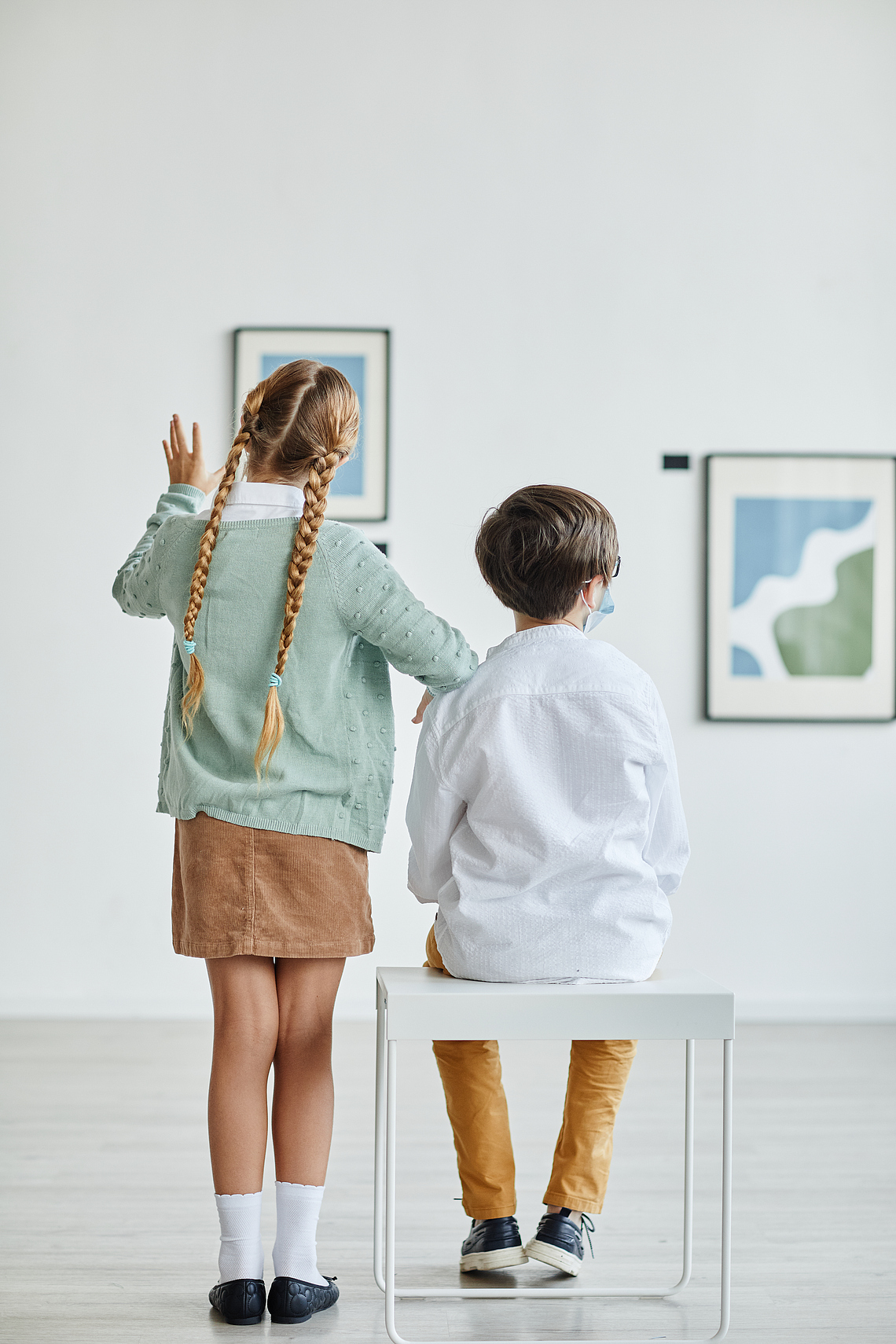 vertical-back-view-boy-girl-looking-paintings-art-gallery