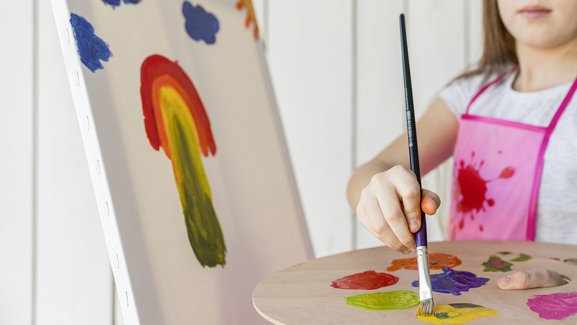 close-up-girl-painting-with-paint-brush-canvas
